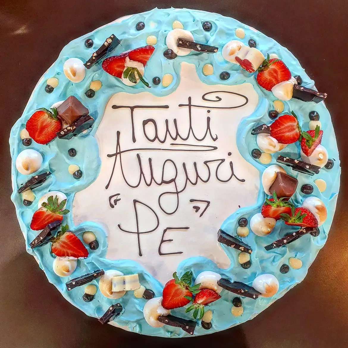 Torta di compleanno Tanti Auguri Pe' con panna azzurra e fragole fresche